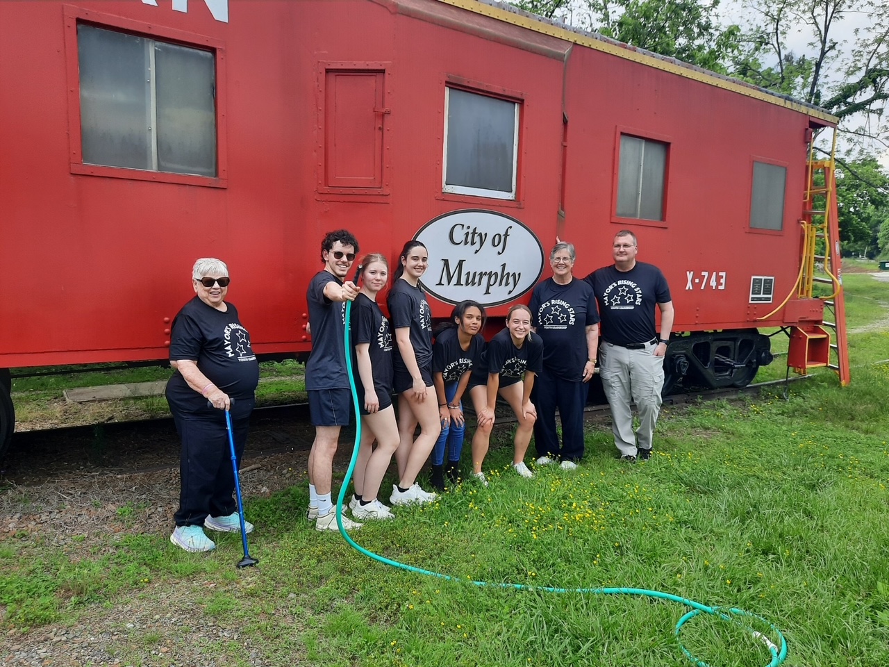 Volunteers in Murphy North Carolina cleaning the City of Murphy red caboose.